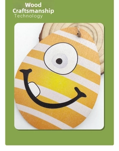 Detail of wooden Easter egg pendant with yellow stripes and cartoon face design