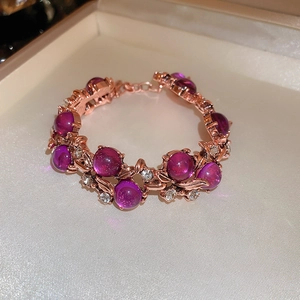 Macro shot of rose gold vintage floral bracelet with purple beads and crystals