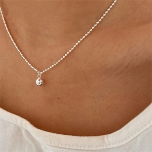 Detailed view of a minimalist 925 sterling silver beaded necklace worn by a model