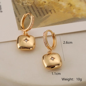 Détail de boucles d'oreilles cœur dorées montrant les dimensions et le zircon brillant