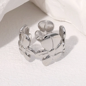 Macro shot of silver flower pattern ring showing smooth metal texture and open band detail