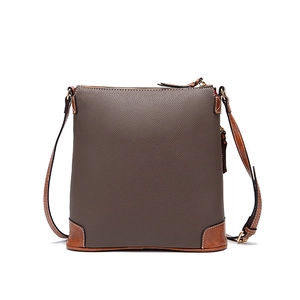 Detail of taupe pebbled leather crossbody bag showing brown reinforced bottom corners