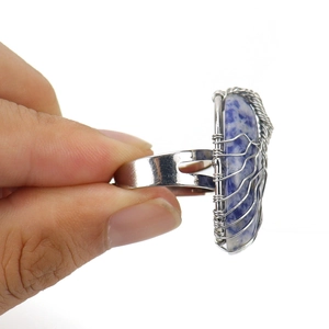 Detail view of handmade wire wrapped tree of life ring with blue crystal stone
