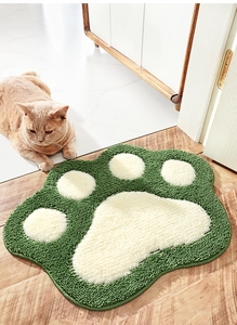Detail of green cat paw bath mat with soft flocking texture on a wooden floor