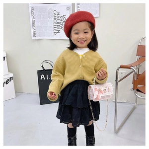 Pink tweed mini bag with pearl handle styled with yellow cardigan and red beret