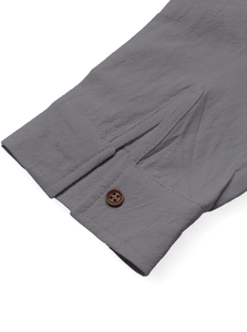 Detail of dark gray cotton linen shirt cuff with a vintage brown button and fabric texture