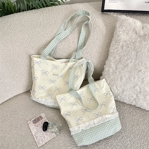 Detailed view of canvas tote bags with lace trim and purple bow patterns in two sizes