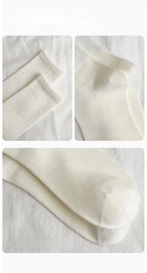 Detail view of elastic cuff, ergonomic heel, and reinforced toe on white cotton socks