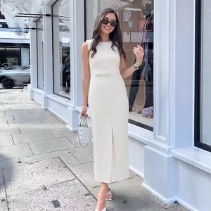 Elegant white sleeveless button-down midi dress with belt shown in a stylish street setting