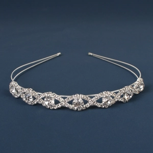 Detail of silver wavy tiara headband with sparkling rhinestones on blue background