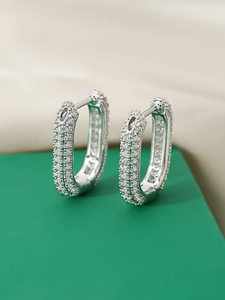 Macro shot of silver U-shaped hoop earrings featuring micro-pave cubic zirconia stones