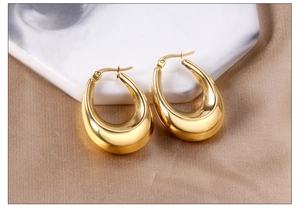 Detailed macro view of gold waterdrop hoop earrings with polished mirror finish texture