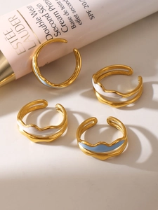 Detailed macro of four-piece double-layered wavy enamel rings in gold and blue finish