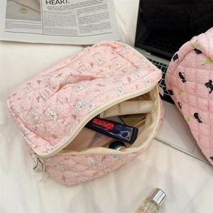 Pink quilted makeup bag with rabbit patterns showing spacious storage for cosmetics