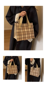 Detail view of khaki plaid canvas tote bag with woven texture and metal buckle closure