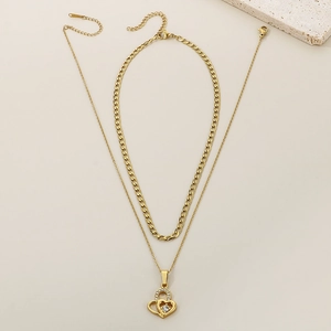 Detail of golden Cuban chain and double heart pendant with sparkling crystals