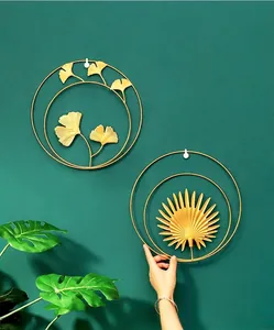 Detail of luxury gold metal leaf wall decor featuring circular double ring design on dark wall