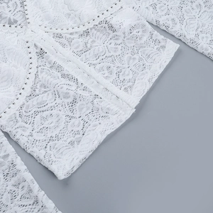 Vue détaillée de la dentelle blanche avec ornements de perles argentées sur la manche