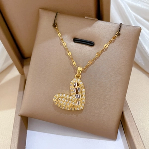 Close-up of heart-shaped gold necklace with pavé zircons in a luxury jewelry box