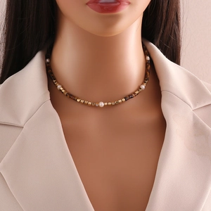 Detail of beaded choker necklace with tiger eye stones, pearls, and golden metal beads