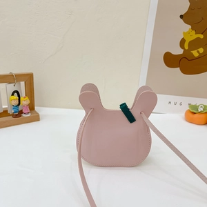 Pink PU leather bunny-shaped crossbody bag for kids with green bow detail and long shoulder strap