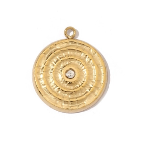 Detail of a hammered texture golden round pendant with a sparkling center zircon