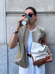 Damen Herbstmode Khaki Weste mit weißem Rock und stilvoller Beuteltasche für draußen