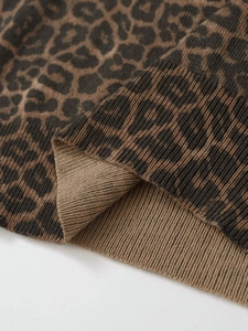 Close-up of leopard print knit fabric with detailed ribbed cuffs and soft texture