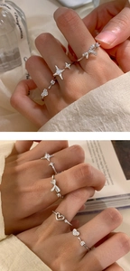 Detailed view of silver bow and star rings with inlaid zircon on warm background
