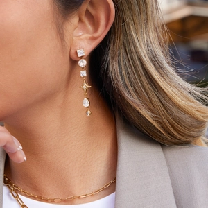 Boucles d'oreilles étoile à franges en acier doré 18K avec zircons sur modèle