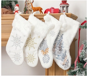 Detailed view of four white plush Christmas stockings with diverse snowflake embroidery