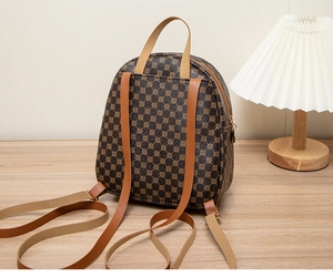 Deep brown backpack with geometric circle pattern and khaki straps on a wooden table