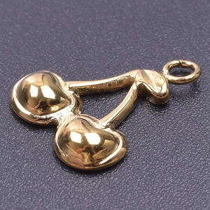 Macro shot of gold cherry pendant charm in 18k plated stainless steel for DIY jewelry