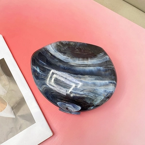 Detail of blue marble acrylic clutch bag with glossy finish and metal clasp on pink background