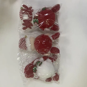 Close-up of plush Christmas ornaments featuring reindeer and Santa styles in knitted hats