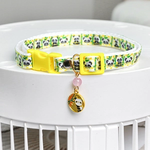 Close-up of pet collar with panda patterns, yellow buckle and bamboo panda pendant