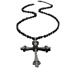 Close-up of gothic cross pendant with intricate relief and black beaded punk style chain