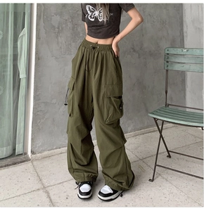 Detail of army green cargo pants featuring adjustable drawstring waist and side pockets