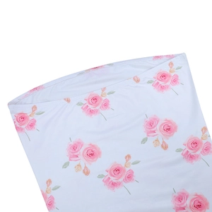 Close-up of pink rose floral print and fine overlock stitching on white fabric