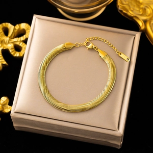 Elegante pulsera de cadena plana de serpiente en acero de titanio dorado sobre caja