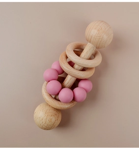 Detail of baby beech wood rattle with pink silicone beads and smooth teething rings