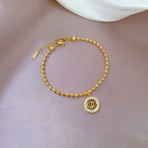 Close-up of golden beaded titanium steel bracelet with interlocking double heart charm