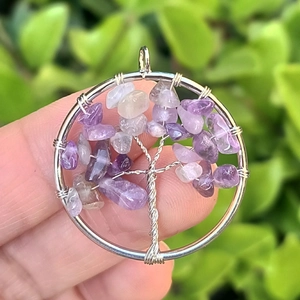 Macro shot of silver wire-wrapped tree of life pendant with purple amethyst stones