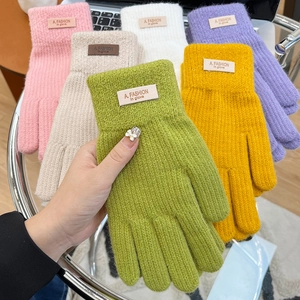 Detail of colorful knit gloves with soft texture and a stylish fashion fabric label