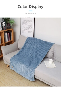 Detail of blue striped flannel throw blanket with soft texture on a cozy grey sofa