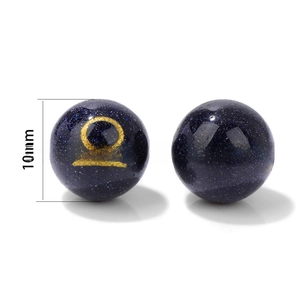 Macro shot of 10mm blue sandstone beads featuring golden Libra and Sagittarius symbols