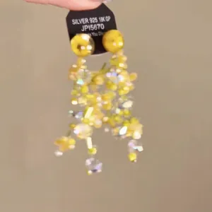 Close-up of long yellow beaded tassel earrings with silver S925 needles and resin flower detail