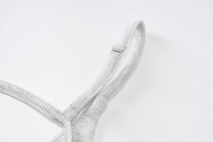 Détail du tissu en maille côtelée grise et boucle de réglage métallique sur la bretelle