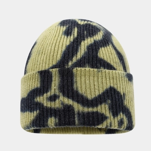 Close-up of olive green and black tie-dye knit beanie with ribbed texture and folded cuff