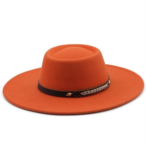 Detail eines orangefarbenen Wollfilzhuts mit geflochtenem Lederband und Metallnieten-Verzierung